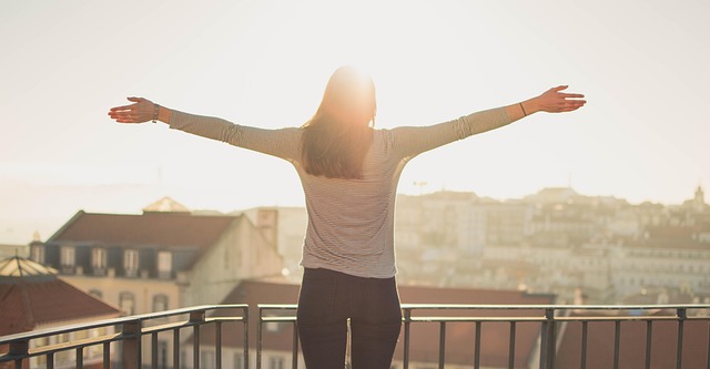 : person standing in morning light expressing gratitude and joy
